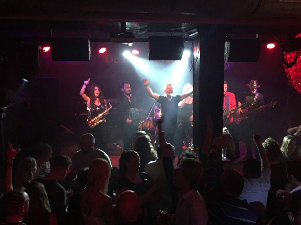 Band plays on stage in dark nightclub